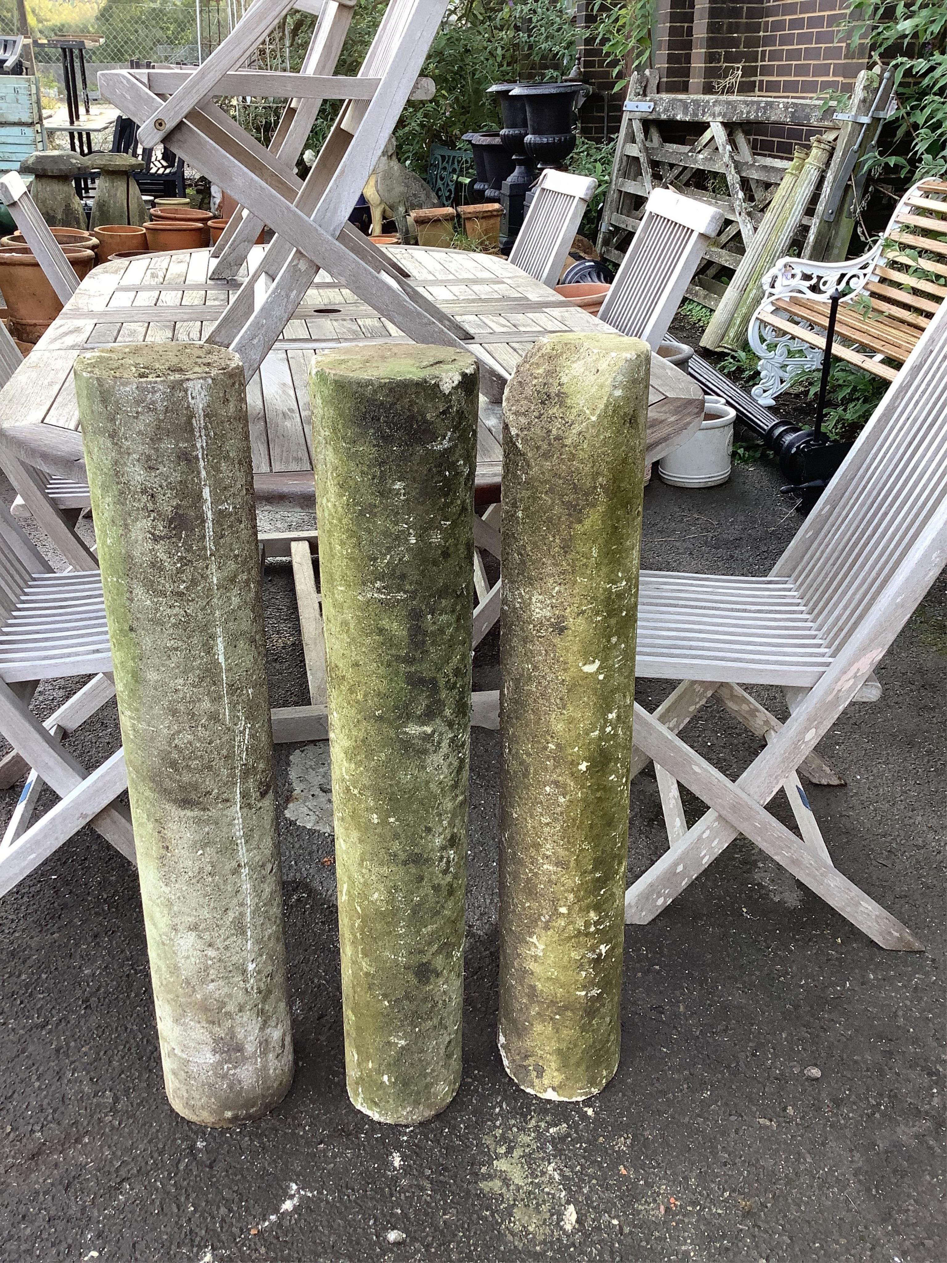 A set of three plain stone columns, diameter 15cm, height 96cm. Condition - weathered condition, one with notable chips at the top and bottom